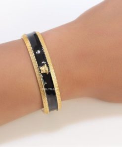 Design Band style black enamel bracelet with gold plated details and gold plated Medusa face motif
